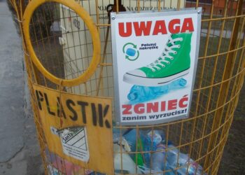 Tarnobrzeg. Pracownicy SanTa-EKO montują tabliczki edukacyjne, na pojemnikach przeznaczonych do selektywnej zbiórki odpadów.