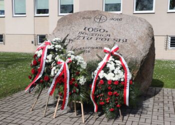 Mielec/Region:  Kwiaty przed obeliskiem upamiętniającym 1050. rocznicę Chrztu Polski.